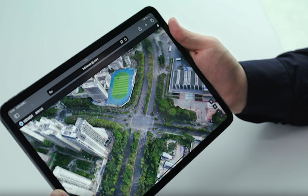 Tablet z interfejsem DJI Modify trzymany w dłoniach.