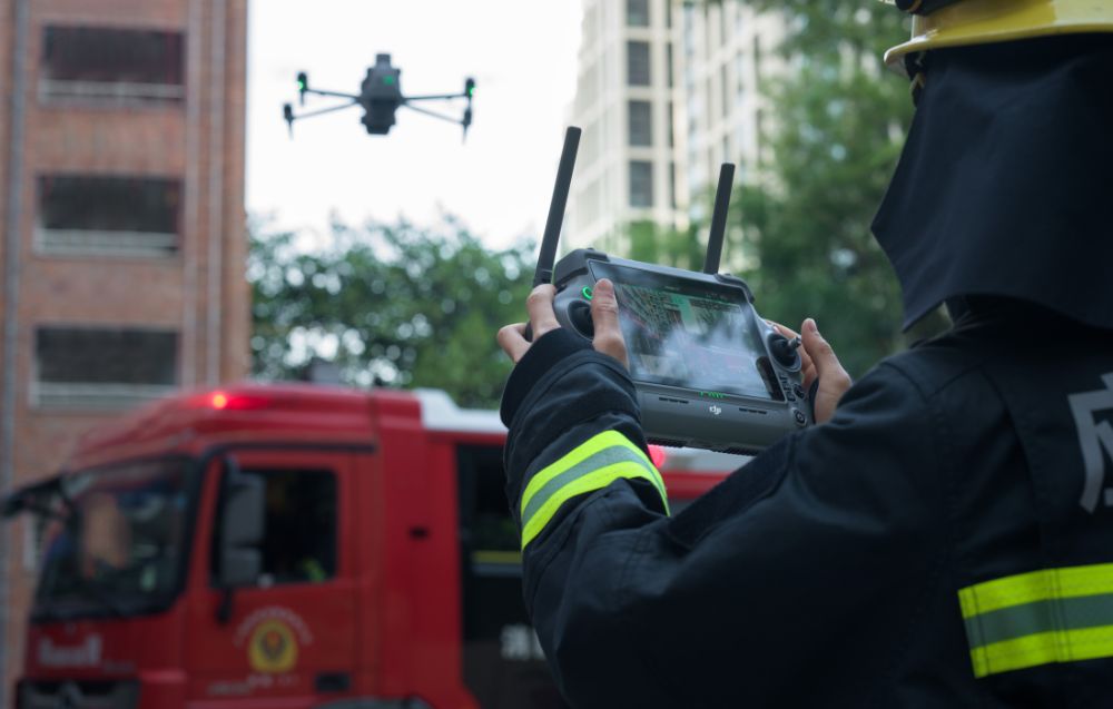 Strażak sterujący dronem z serii Matrice 4 w mieście.