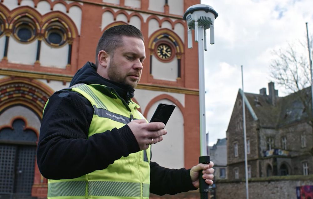 Mężczyzna korzystający ze smartfona i stacji D-RTK 3.